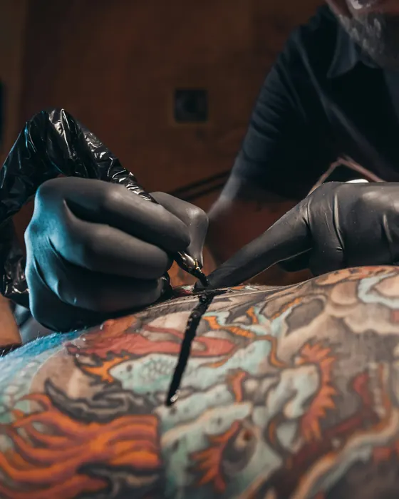 Black-gloved hands shading a colour back piece